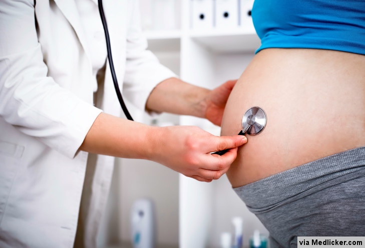Lékař vyšetřuje břicho těhotné pacientky