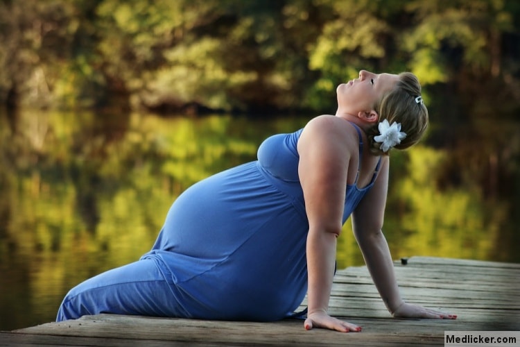 Pregnant woman on lake shore