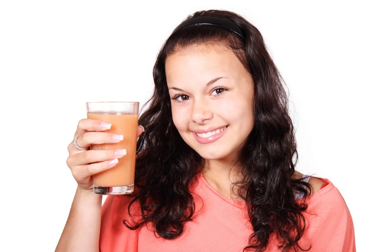 Girl holding a glass of pear juice