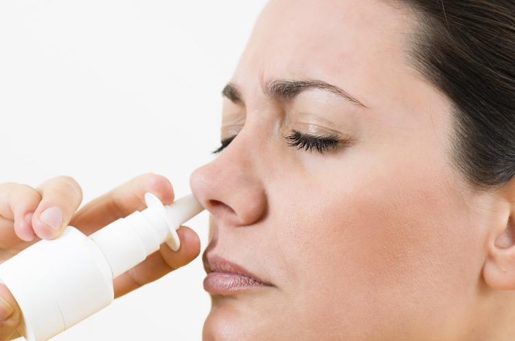 Woman using nasal spray